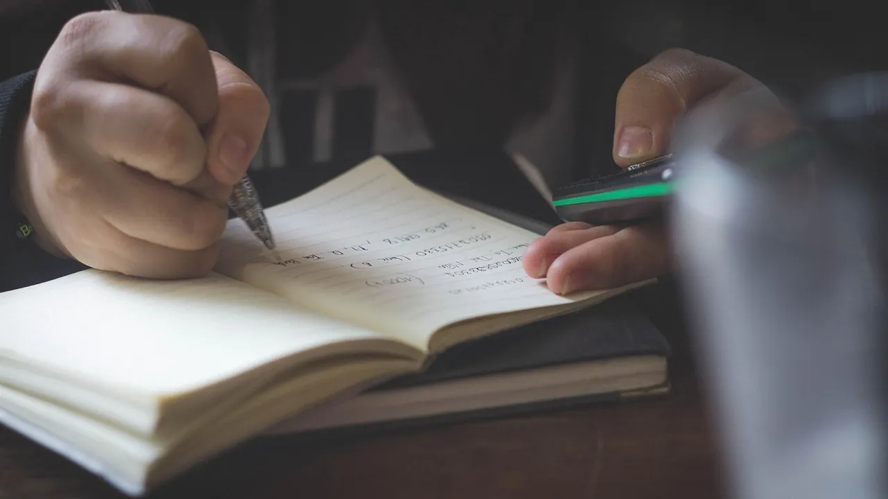 Main qui écrit dans un carnet ouvert